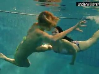 Two enchanting amateurs showing their bodies off under water